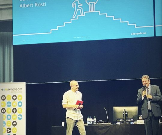 SP-Nationalrat David Roth begrüsste SVP-Bundesrat und Medienminister Albert Rösti, der später auch noch eine «To-do-Liste» in die Hand gedrückt bekam...    (Bild: © Kongress Klein Report)