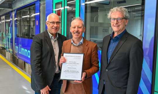 Preisträger Hansjürg Zumstein umrahmt von Vereinspräsident Gerhard Lob und Jurypräsident Peter Moor an der Hauptversammlung im Depot der Limmattalbahn. (Foto © Stefan Treier)