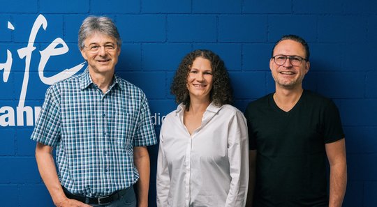 Hansjörg Keller (l.) gibt die Leitung von Radio Life Channel an Michelle Boss und Simon Müller (r.) ab... (Bild: ERF Medien)