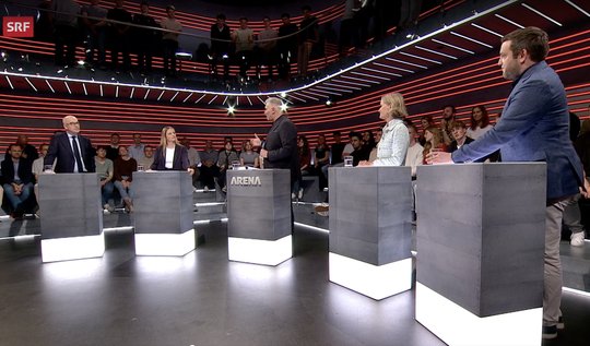 Arena-Moderator Sandro Brotz (Mitte) umgeben von Gregor Rutz, Zürcher SVP-Nationalrat, Melanie Racine, Vizepräsidentin Jungfreisinnige, Andrea Gmür-Schönenberger, Ständerätin «Die Mitte», und SP-Vizepräsident Jon Pult (v. l., Bild: SRF-Screenshot)