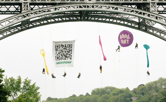 Die Aktionswoche wurde am Samstag in Bern eingeläutet, wo Aktivisten und Aktivistinnen sechs Meter langes, farbiges Besteck und Teller von der Kirchenfeldbrücke hängen liessen... (© Bild: Greenpeace)