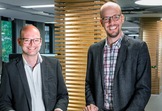 Sie arbeiten seit Längerem schon zusammen: Dominik Schaetz, Team Manager Digital Analytics, und CEO Raphael Bienz unterschreiben die Papiere zur Übernahme (v.l.)