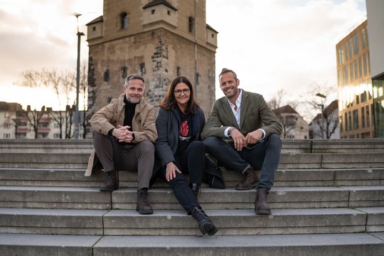 Die Geschäftsleitung von Mediawolf: Marc Görtz, Dietlinde Stroh, Björn Hering (r.) auf den Treppen nach oben in Köln...          (Bild: zVg)