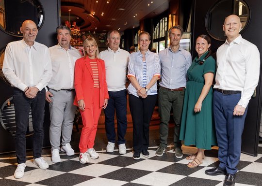 Juliane Merz im roten Blazer und Tarkan Özküp (ganz rechts) im Igem-Vorstand: Präsident Stephan Küng (l.), Alexander Duphorn, Xavier Reynaud, Siri Fischer, Frank Zelger und Sandra Fehr... (Bild: zVg/© Oskar Moyano)